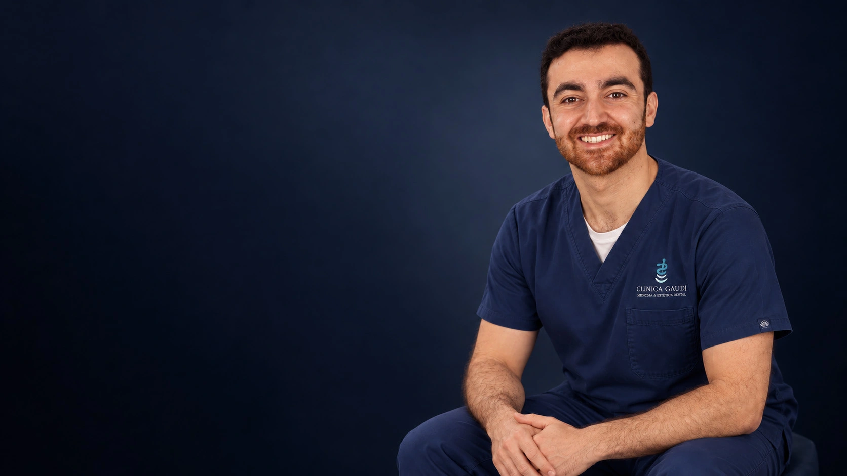 Retrato del Dr. Albert Ferré sonriendo, en un estudio fotográfico sobre fondo azul noche.